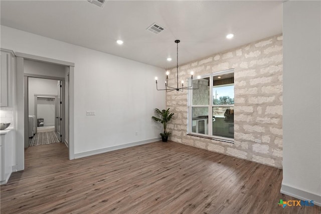 unfurnished dining area featuring a chandelier, wood finished floors, visible vents, and recessed lighting