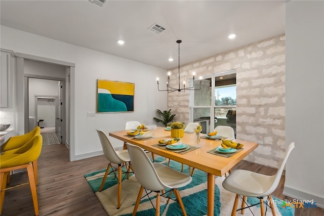 dining area featuring baseboards, visible vents, wood finished floors, a chandelier, and recessed lighting