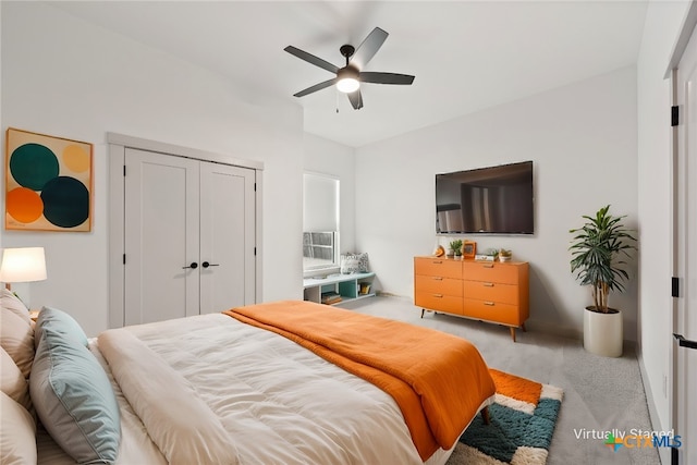 bedroom featuring lofted ceiling, a closet, a ceiling fan, and light colored carpet