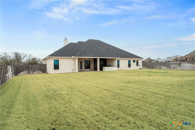 rear view of property featuring a fenced backyard, a chimney, a patio, and a yard