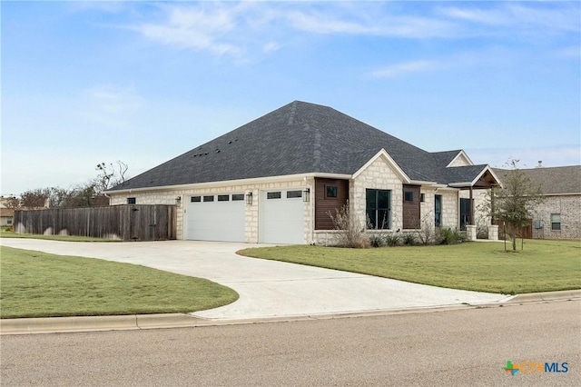 view of front of property with concrete driveway, an attached garage, fence, stone siding, and a front lawn