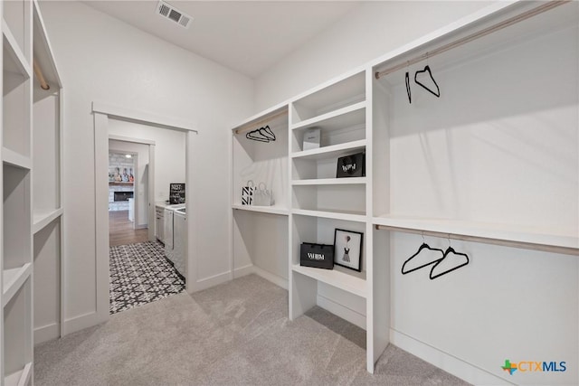 spacious closet with carpet, visible vents, and washing machine and clothes dryer