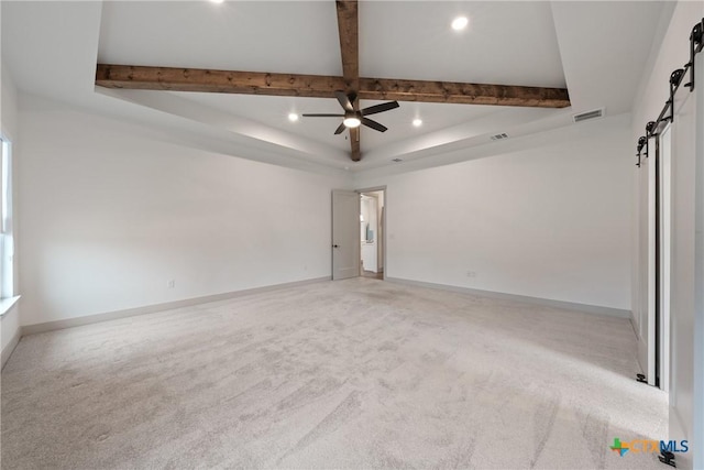 spare room with beam ceiling, recessed lighting, visible vents, a barn door, and baseboards