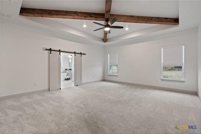 carpeted empty room featuring recessed lighting, beamed ceiling, baseboards, and a barn door