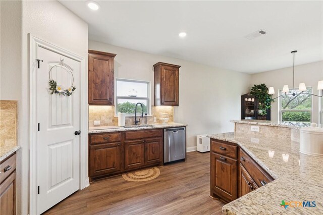 304 Campo Colinas Dr, Bertram, TX 78605 - kitchen with stainless steel dishwasher, healthy amount of natural light, backsplash, wood finished floors, and recessed lighting