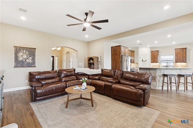 304 Campo Colinas Dr, Bertram, TX 78605 - living area with arched walkways, ceiling fan, light wood-style floors, and recessed lighting