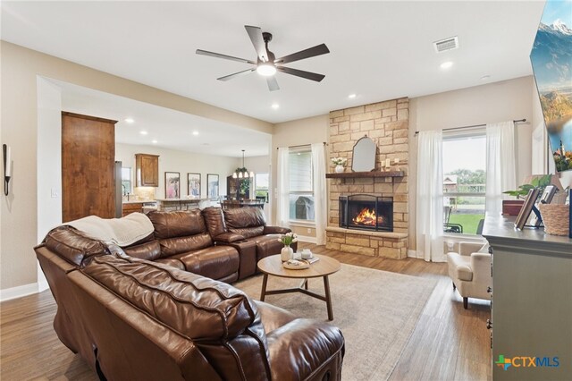 304 Campo Colinas Dr, Bertram, TX 78605 - living area featuring ceiling fan, light wood-style floors, a stone fireplace, and recessed lighting