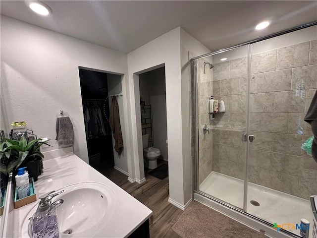 1036 Chambray Dr, Troy, TX 76579 - bathroom featuring wood finished floors, a stall shower, double vanity, a spacious closet, and recessed lighting