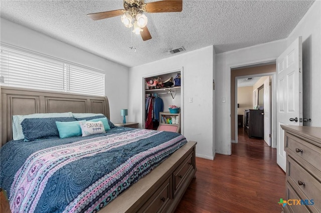 bedroom featuring a textured ceiling, dark wood-type flooring, a closet, and ceiling fan