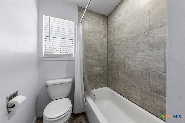 bathroom with shower / tub combo with curtain and toilet