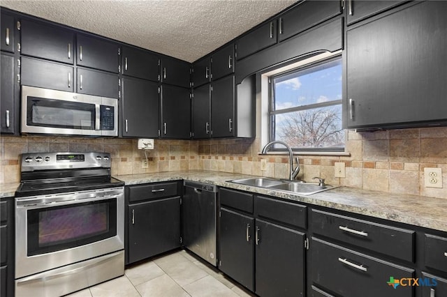 kitchen with backsplash, stainless steel appliances, sink, and light tile patterned floors