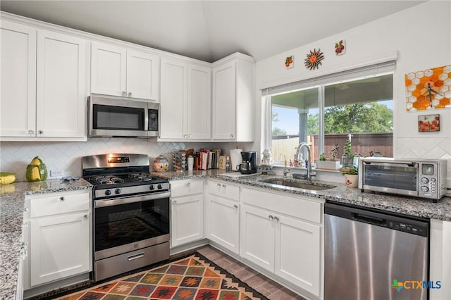 128 Riverhill Dr, Georgetown, TX 78628 - kitchen with appliances with stainless steel finishes, a sink, backsplash, white cabinets, and light stone countertops