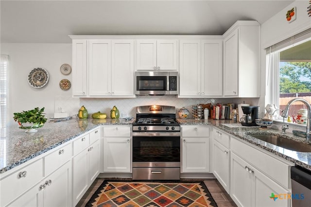 128 Riverhill Dr, Georgetown, TX 78628 - kitchen with appliances with stainless steel finishes, a sink, white cabinetry, and tasteful backsplash