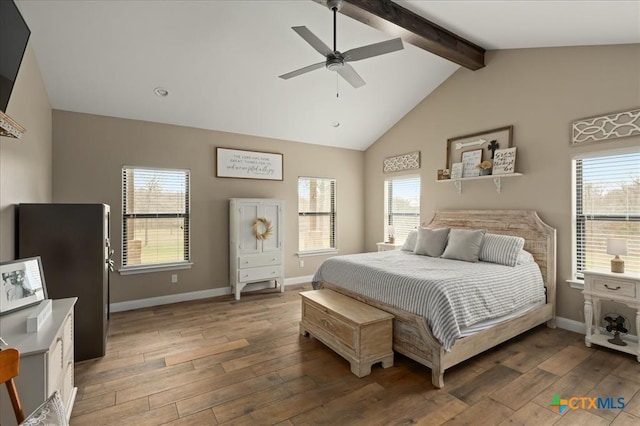 bedroom featuring dark hardwood / wood-style flooring, ceiling fan, and vaulted ceiling with beams