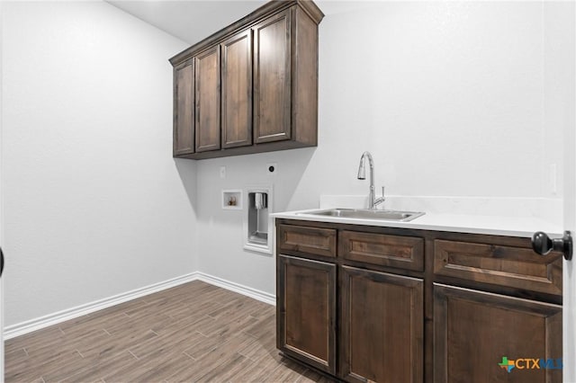 laundry room featuring sink, electric dryer hookup, cabinets, washer hookup, and light wood-type flooring