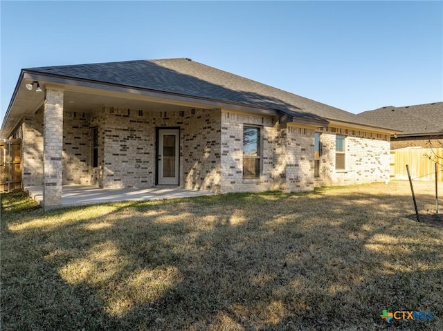 rear view of property featuring a patio area and a lawn