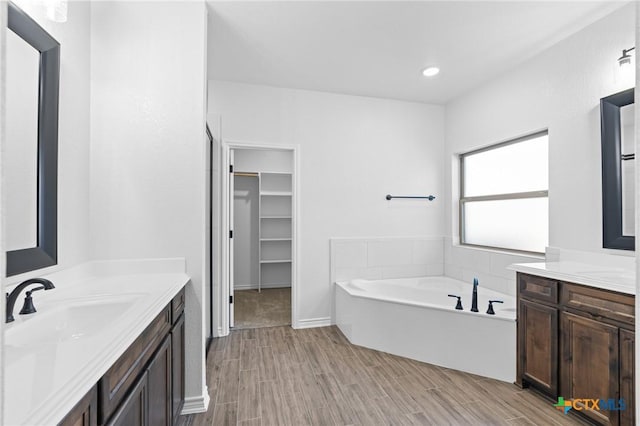 bathroom featuring vanity, hardwood / wood-style floors, and a washtub