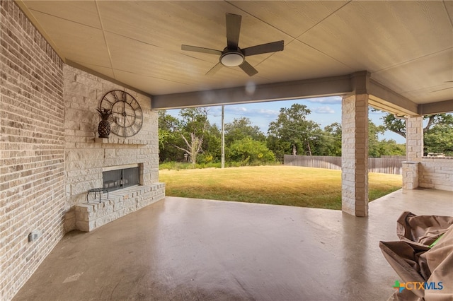 view of patio with ceiling fan and an outdoor stone fireplace