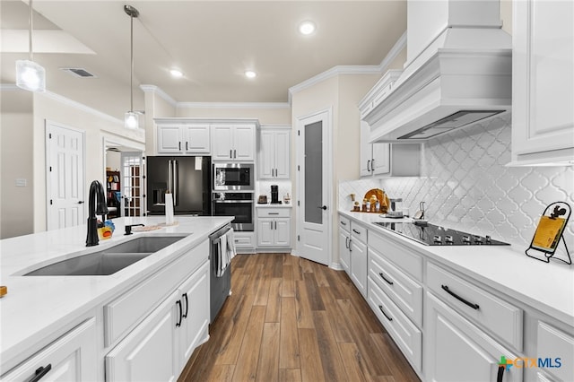 kitchen featuring sink, appliances with stainless steel finishes, custom range hood, and white cabinets