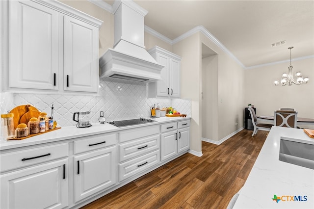 kitchen with white cabinets, a chandelier, custom exhaust hood, ornamental molding, and dark hardwood / wood-style floors