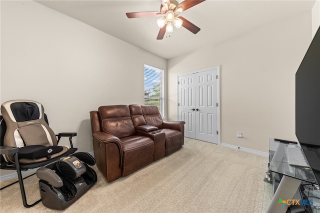 carpeted living room with ceiling fan and vaulted ceiling