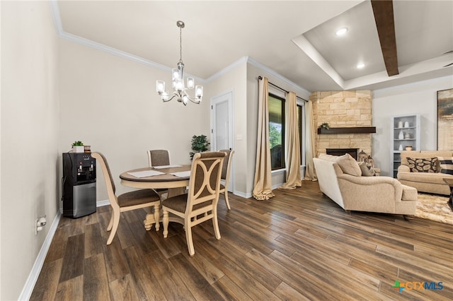 dining space with dark wood-type flooring, beamed ceiling, a notable chandelier, and a fireplace