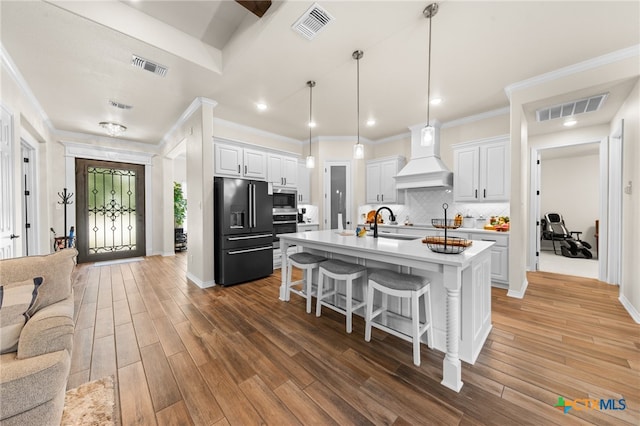 kitchen featuring stainless steel appliances, custom range hood, white cabinetry, and dark wood-type flooring