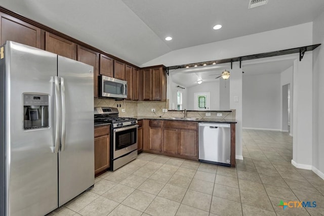 2588 Diamondback Trl, New Braunfels, TX 78130 - kitchen featuring appliances with stainless steel finishes, vaulted ceiling, backsplash, a ceiling fan, and light tile patterned floors