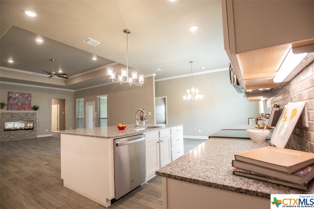 kitchen with a center island with sink, pendant lighting, sink, white cabinets, and stainless steel dishwasher