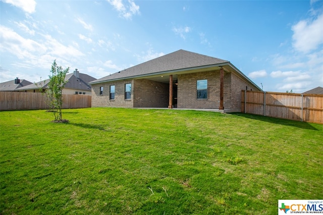 rear view of property with a lawn