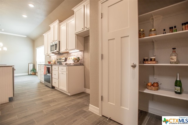 kitchen with stainless steel appliances, light hardwood / wood-style floors, and white cabinets