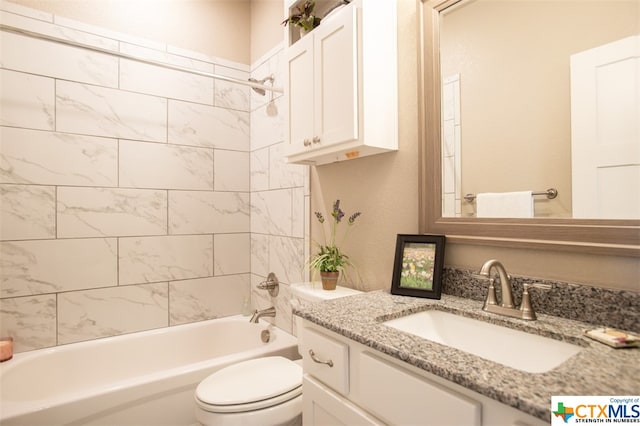 full bathroom featuring vanity, tiled shower / bath combo, and toilet