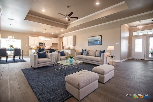 1027 Winchester Dr, Nolanville, TX 76559 - living room with a raised ceiling, a chandelier, plenty of natural light, baseboards, and crown molding