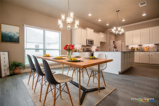 dining room featuring dark wood-type flooring, a chandelier, and ornamental molding