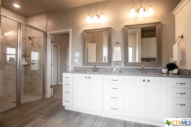 bathroom with vanity, hardwood / wood-style flooring, and a shower with door