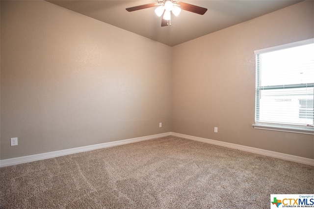 empty room featuring ceiling fan and carpet