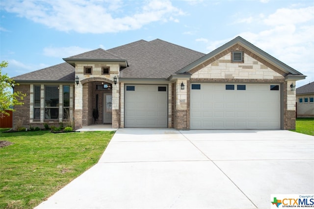 view of front of property featuring a garage and a front lawn