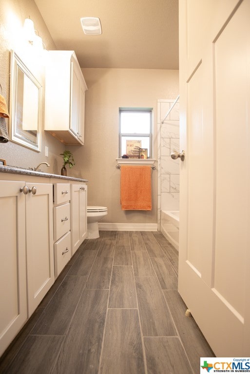 full bathroom featuring toilet, vanity, and tiled shower / bath