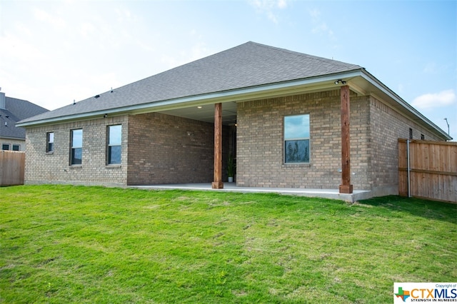 back of property with a patio and a yard