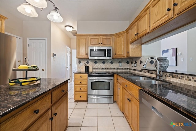 2109 Grizzly Trl, Harker Heights, TX 76548 - kitchen featuring stainless steel appliances, a sink, tasteful backsplash, light tile patterned floors, and dark stone counters