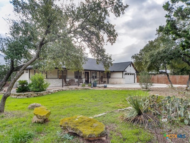 view of front of home with covered porch, a front yard, and a garage