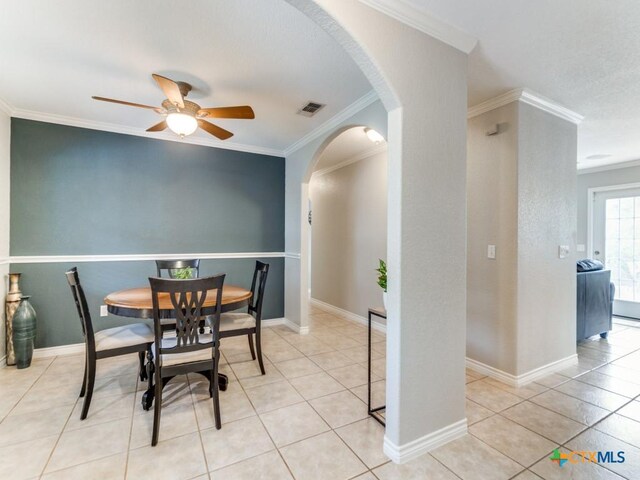 dining room with ceiling fan, ornamental molding, and light tile patterned floors