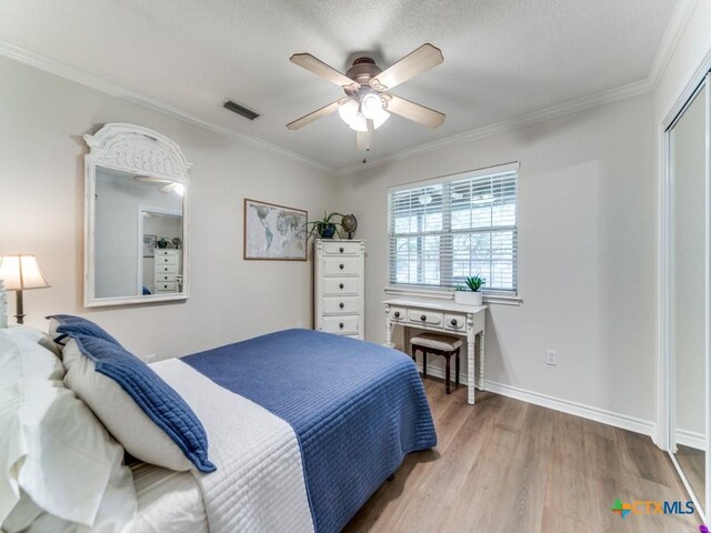 bedroom with hardwood / wood-style floors, a closet, ceiling fan, and ornamental molding