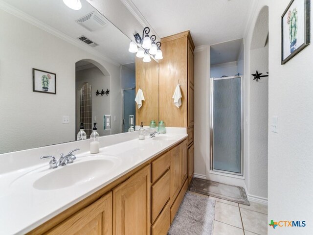 bathroom featuring tile patterned floors, vanity, ornamental molding, and walk in shower