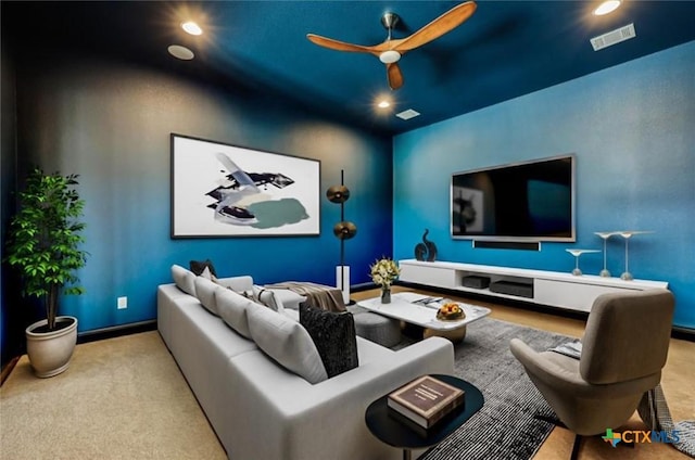 carpeted home theater with ceiling fan