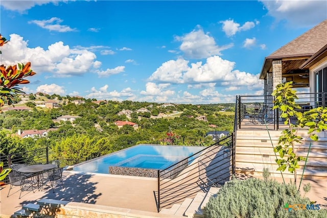 view of swimming pool featuring an in ground hot tub and a patio