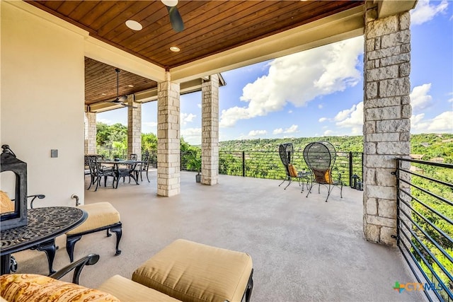 view of patio featuring ceiling fan and an outdoor stone fireplace