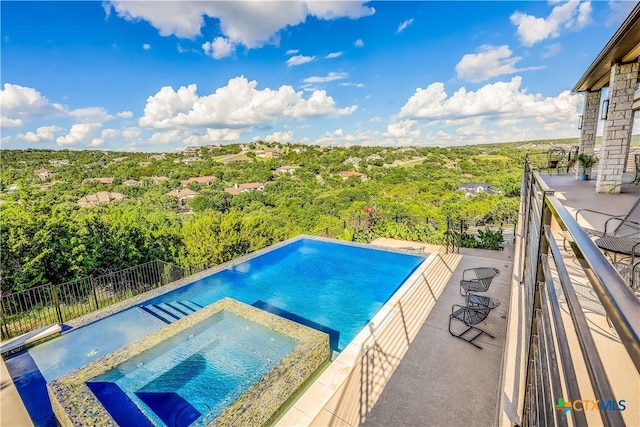 view of swimming pool with an in ground hot tub