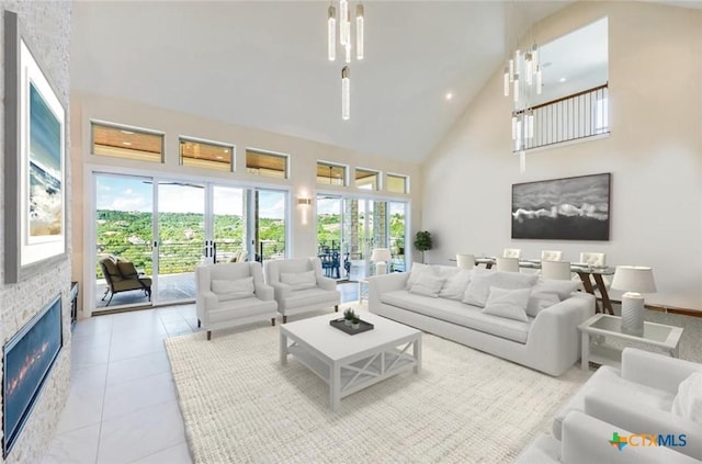 living room with plenty of natural light, light tile patterned floors, a fireplace, and a high ceiling