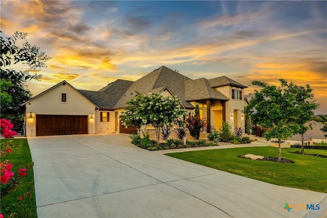 view of front of home with a yard and a garage